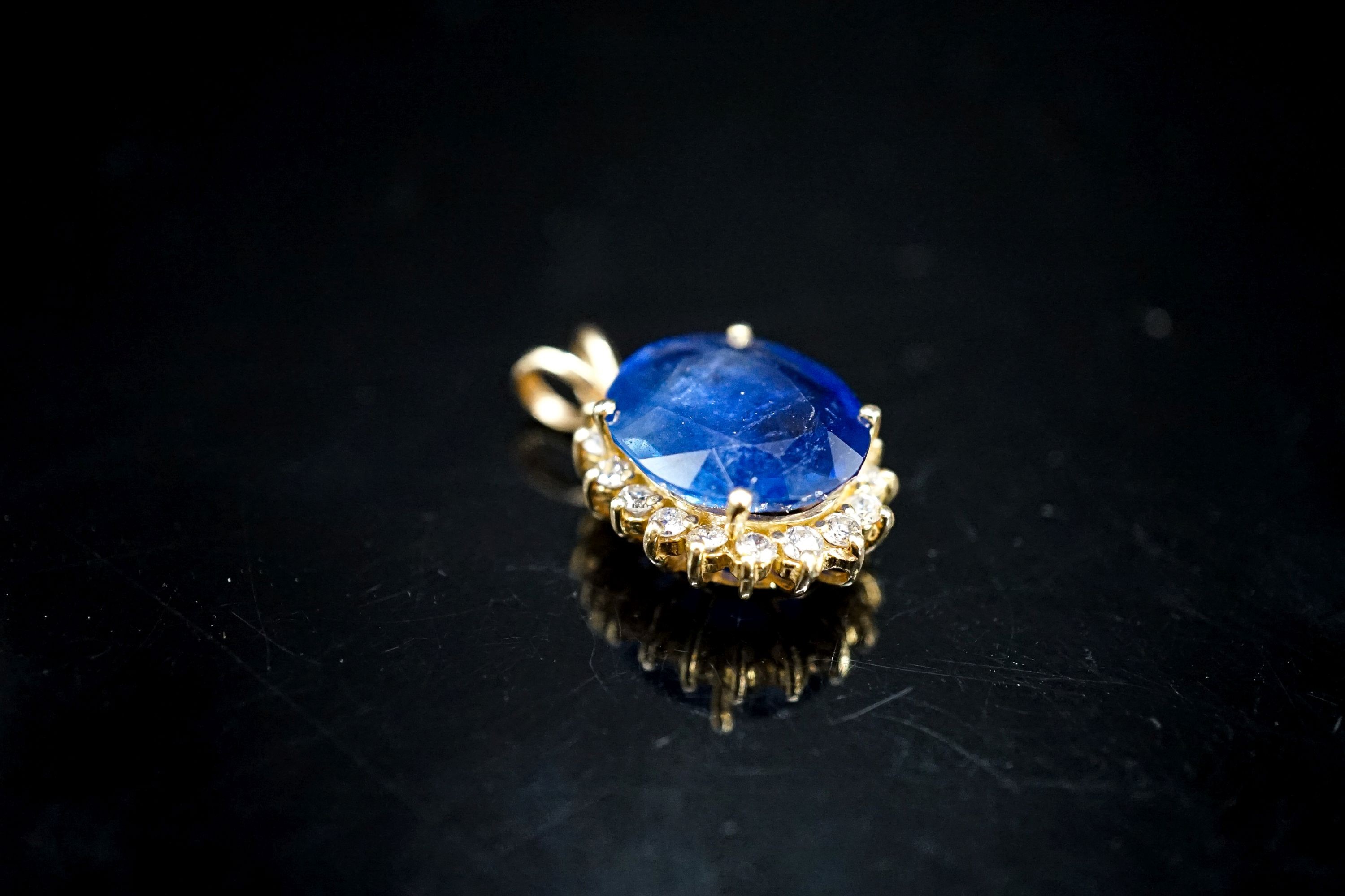 A yellow metal mounted sapphire and diamond set oval cluster pendant, 23mm, gross 4.6 grams.